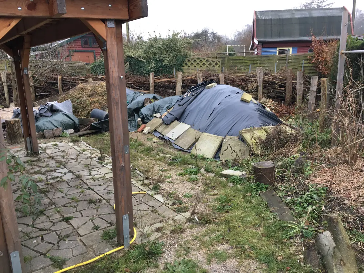 Abgegrabener nährstoffreicher Boden aus dem Garten – aufgeschüttet und lichtdicht mit schwarzer Folie abgedeckt