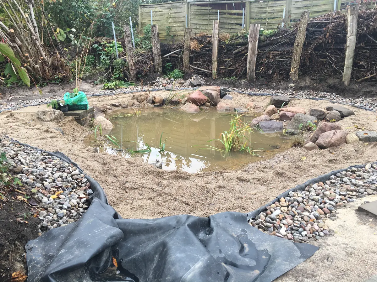 Letzte Handgriffe am Ufer – Kapillarsperre abdichten und die ersten Wasserpflanzen setzen