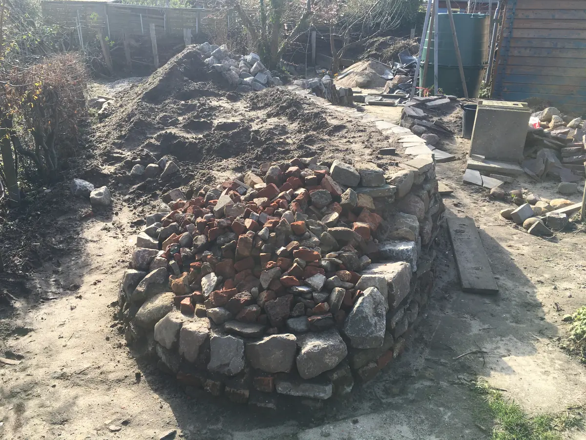 Strukturgebender Steinhaufen am Kopfende – jetzt wird die andere Flanke gebaut
